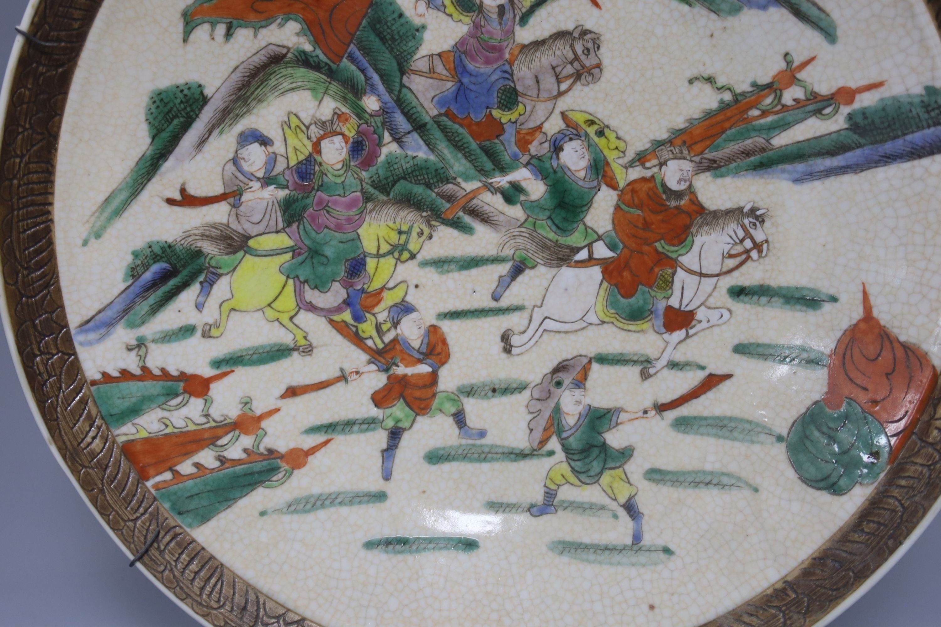 A Chinese crackle glaze dish, early 20th century, depicting a battle scene 33cm